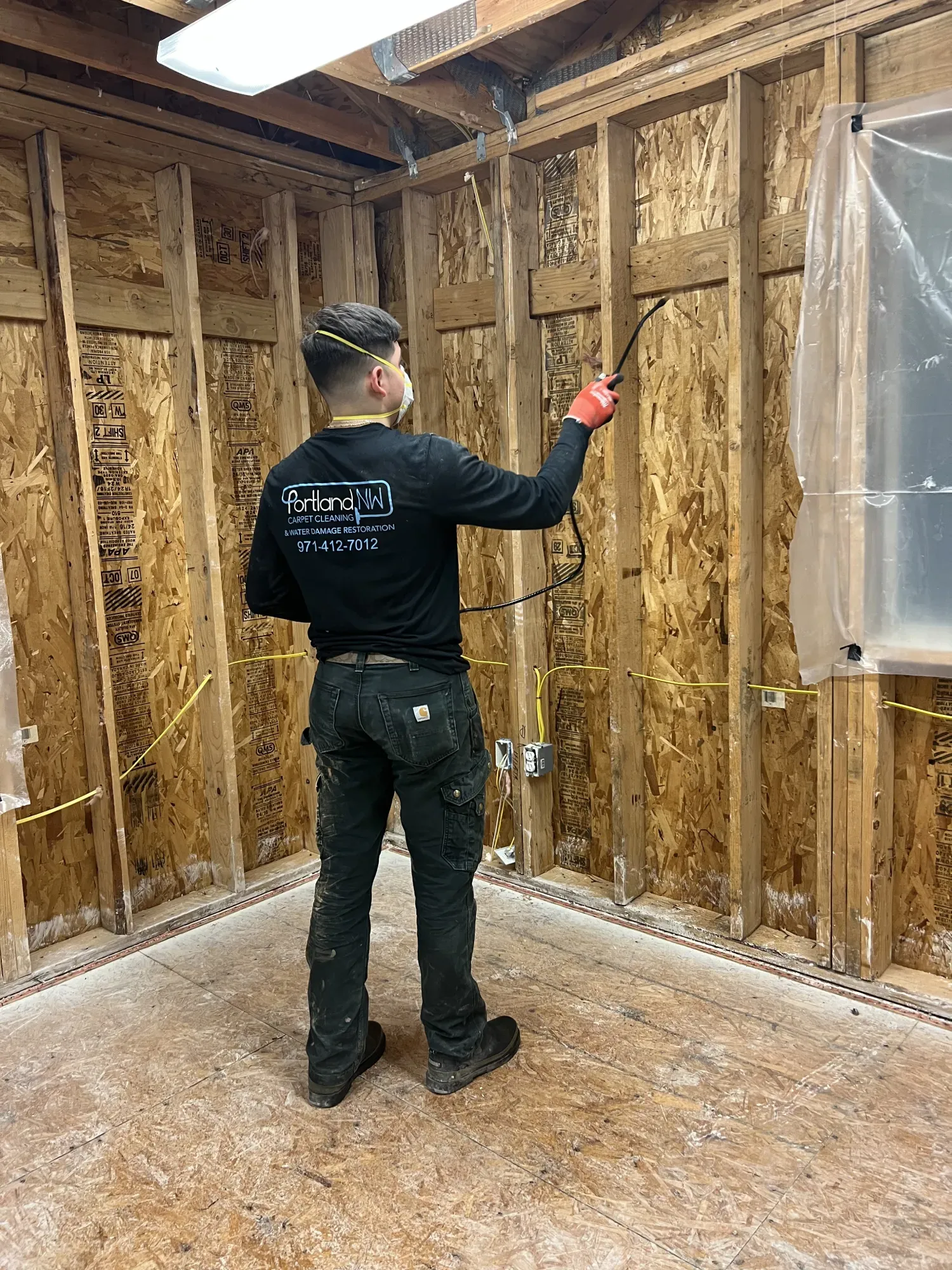 Restoration technician treating a damaged wooden frame